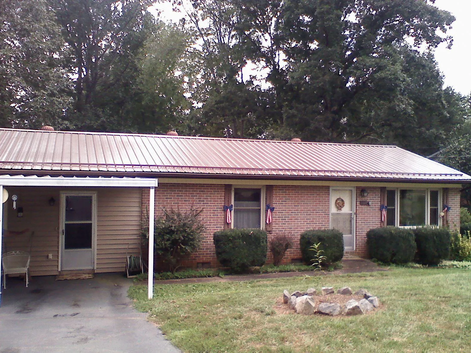 Bronze metal roof and carport on a brick ranch home — Roof Repair work by our crew in Fort Meade